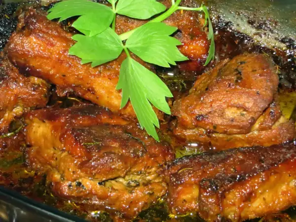 Soczyste żeberka w miodzie, pieczone do perfekcji, skąpane w aromatycznym sosie. Zielona gałązka dodaje świeżości.