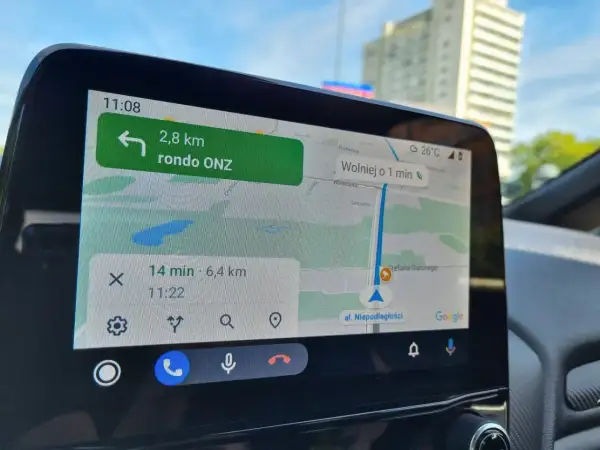 Nawigacja w samochodzie pokazuje trasę do ronda ONZ. Wyznaczanie azymutu na mapie jest kluczowe dla sprawnego dotarcia do celu.