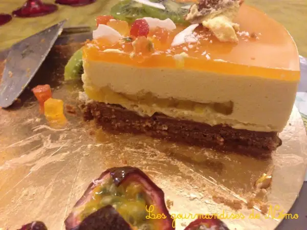 Tranche de gâteau mousseux à l'orange et au fruit de la passion, garnie de fruits et de kiwi.