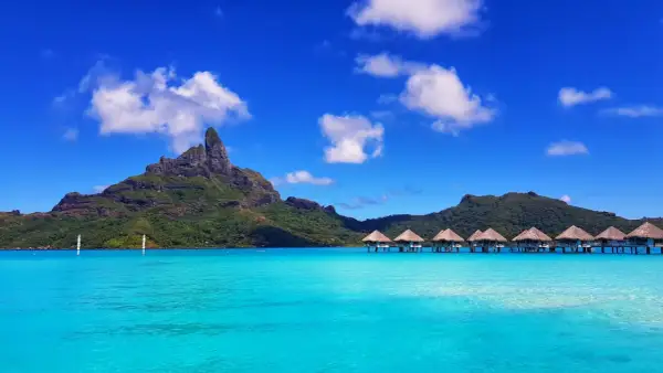 Bora Bora: idealna pogoda, turkusowa woda, góry i domki na wodzie.
