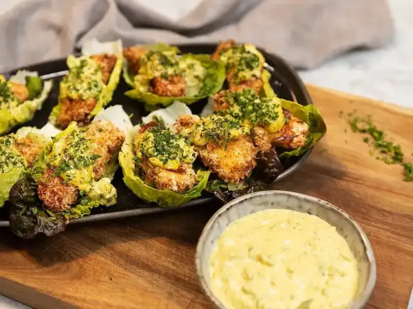 Krispiga bitar i salladsblad toppade med en krämig sås. Perfekt tillbehör till ditt remouladsås recept.