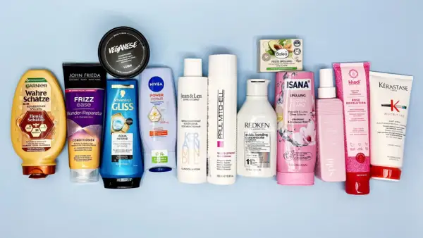Eine Auswahl an Haarspülungen, darunter Produkte von Garnier, John Frieda und Nivea, einige mit Inhaltsstoffen wie Stearamidopropyl Dimethylamine für glänzendes Haar.
