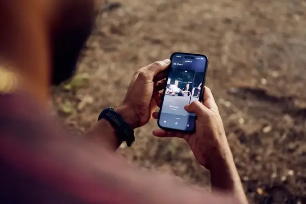 Une application de fitness running s'affiche sur un smartphone tenu par une personne.