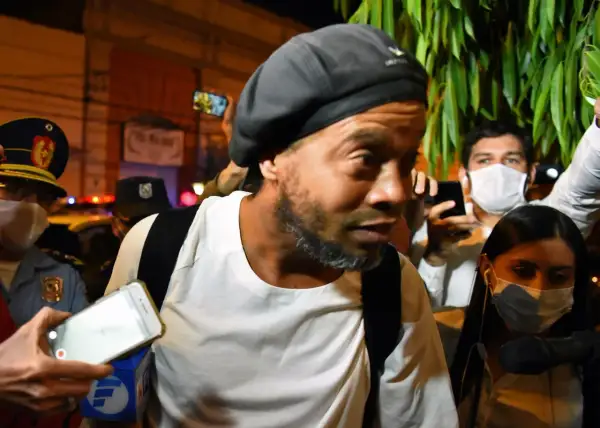 Ronaldinho w otoczeniu policji i tłumu, z telefonami skierowanymi na niego. Słynny piłkarz, którego losy potoczyły się w nieoczekiwany sposób, w tym do więzienia.
