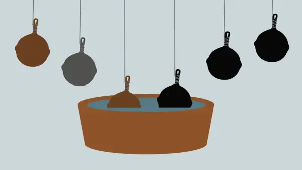 En rostig muurikka doppas i en balja. Andra muurikkor hänger ovanför, vissa mörka, andra grå.