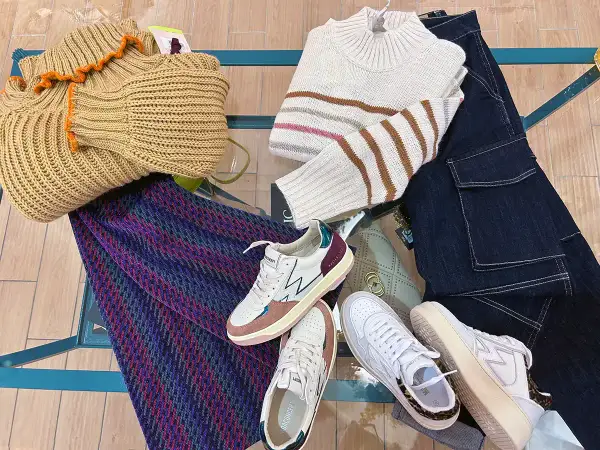 Sneakers: cosa sono? Scarpe comode e alla moda, perfette per ogni outfit. Ecco un esempio di look casual con maglioni, jeans e una borsa.