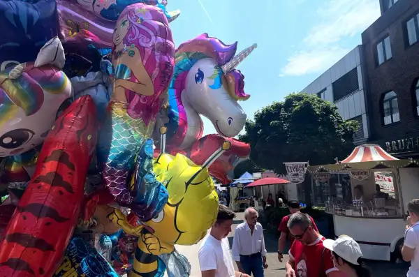 Bunte Ballons mit Einhorn und Meerjungfrau beim Stadtfest Bensberg. Menschen schlendern an Ständen vorbei.