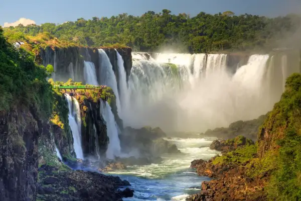 Impresionantes cascadas en América del Sur, con una pasarela verde para observar la majestuosidad del agua cayendo entre la exuberante vegetación.