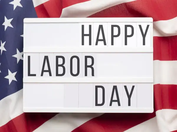 Cartel luminoso con "HAPPY LABOR DAY" sobre bandera de EE.UU. Celebrando el día del trabajador en inglés.