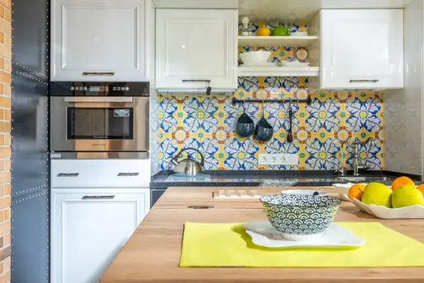 Azulejos vibrantes con motivos florales y geométricos ofrecen fantásticas ideas para pared de cocina. Blanco y azul sobre amarillo crean un ambiente alegre.