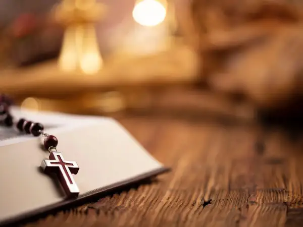 Różaniec na otwartej księdze, symbol wiary. Czasem nawet dziwne imiona świętych prowadzą do głębokiej refleksji.