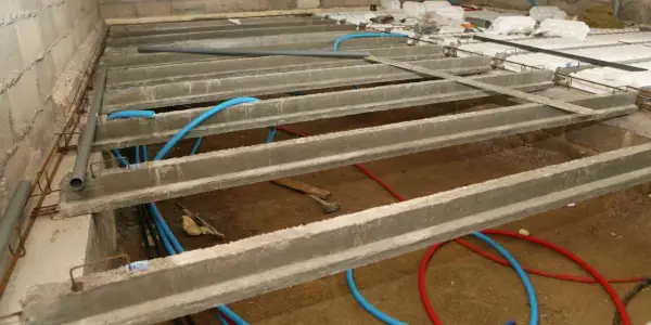 Construction d'un vide sanitaire avec poutrelles béton et tuyaux bleus. Préparation pour comment ventiler un vide sanitaire.