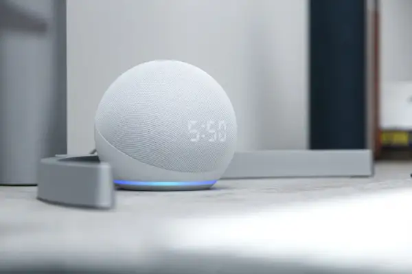 Altavoz inteligente blanco con luz azul, mostrando la hora. Descubre todo lo que puede hacer Alexa para simplificar tu día.