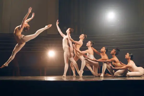 Tancerki na scenie prezentują różne rodzaje tańca, od dynamicznych skoków po eleganckie pozy.
