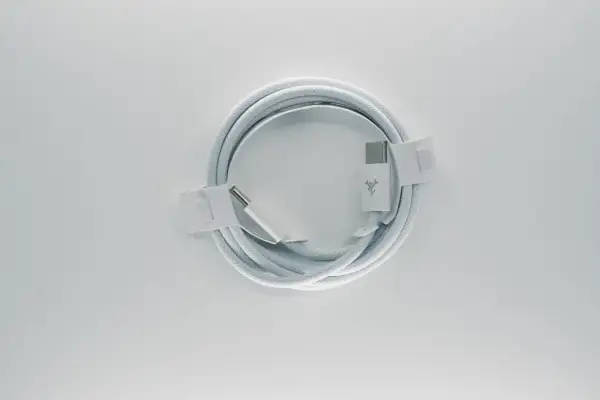 Biały kabel z końcówkami USB-C, zgodny ze standardem USB C, zwinięty na białym tle.
