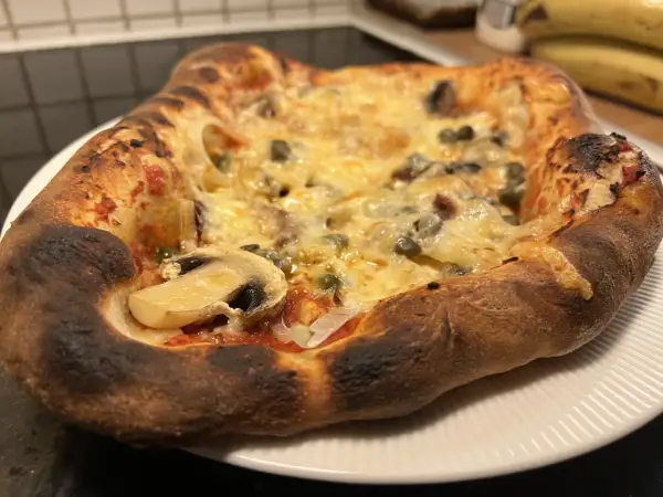 En nybakad pizza med svamp och kapris, perfekt för ett mysigt kvällsmål. Detta är ett fantastiskt pizza recept!