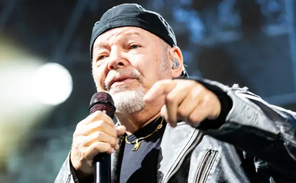 Vasco Rossi canta con passione, puntando il dito. I suoi testi, come "non mi va", risuonano potenti.