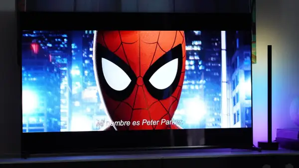 Spider-Man na ekranie telewizora, porównanie technologii QD OLED vs OLED. W tle nocne miasto.