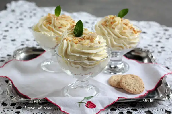 Cremige Desserts in Gläsern, garniert mit Mandelsplittern und Minze. Ein Hauch von Zitrone, wie bei einem feinen lemon curd, macht sie unwiderstehlich.