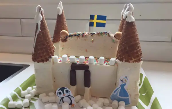 En fantasifull glasstårta formad som ett slott, perfekt för barn. Med svenska flaggan på toppen och dekorerad med marshmallows, strössel och söta figurer.