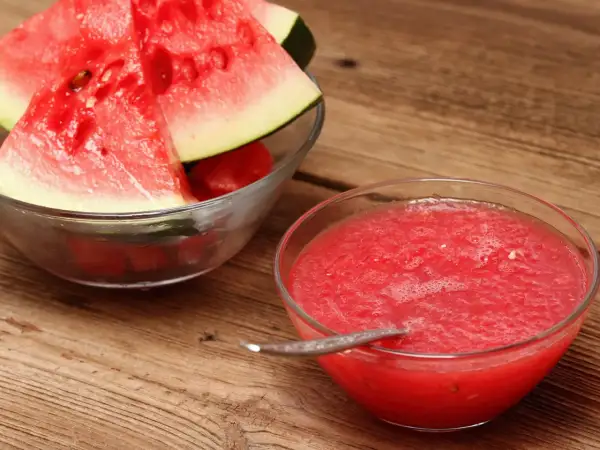 Frische Wassermelonenscheiben in einer Schüssel und eine Schüssel mit leckerer, selbstgemachter Melonen Marmelade.