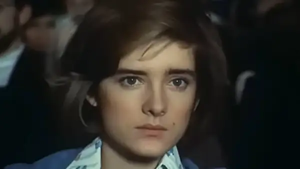 Małgorzata Snopkiewicz dzisiaj, młoda dziewczyna z krótkimi włosami i przenikliwym spojrzeniem, w niebieskiej marynarce.