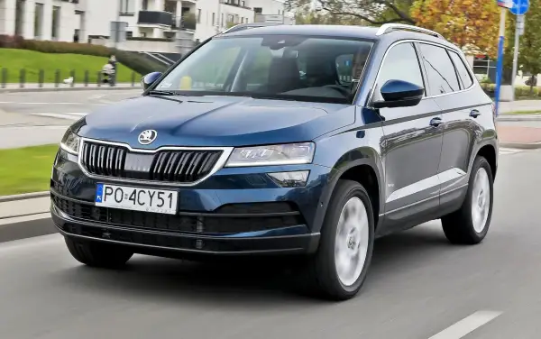 Niebieska Skoda Karoq w ruchu miejskim. Wiele osób szuka skoda karoq opinie przed zakupem.