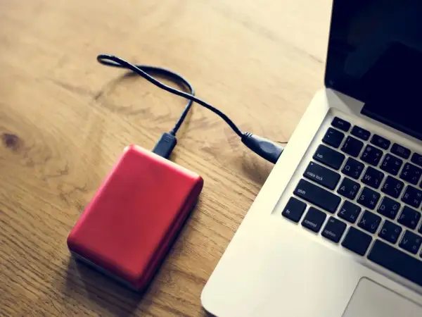 Czerwony dysk zewnętrzny podłączony do laptopa. Komputer nie widzi dysku zewnętrznego, co może być frustrujące.