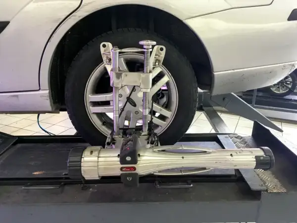 Réglage du parallélisme voiture avec un appareil de mesure sur une roue.