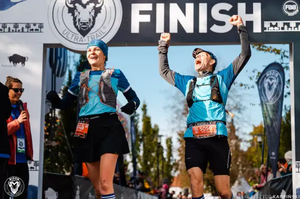 Dwaj biegacze z radością przekraczają linię mety Bison Ultra-Trail Supraśl.
