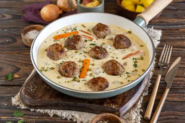 Herzhafte Frikadellen in cremiger Soße mit Erbsen und Karotten, ein köstliches Wikingertopf Rezept.