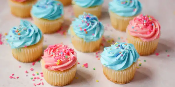 Söta cupcakes med blå och rosa frosting, strössel. Perfekt för ett gender reveal tårta recept.