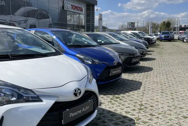 Rząd lśniących, **toyota używane z salonu** czeka na nowych właścicieli. Wśród nich biała, niebieska i grafitowa.