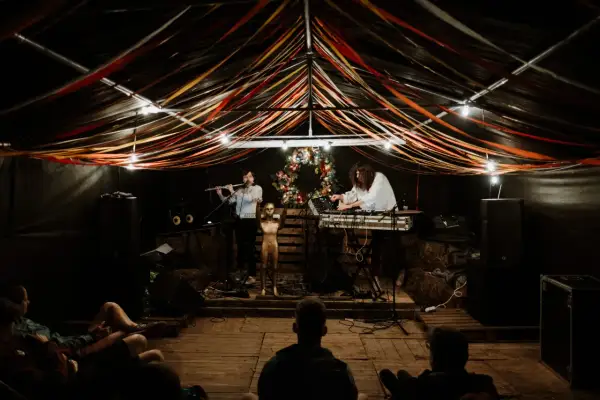 Muzycy grają na scenie pod kolorowymi wstążkami. Atmosfera jak na **grajdół festiwal**.