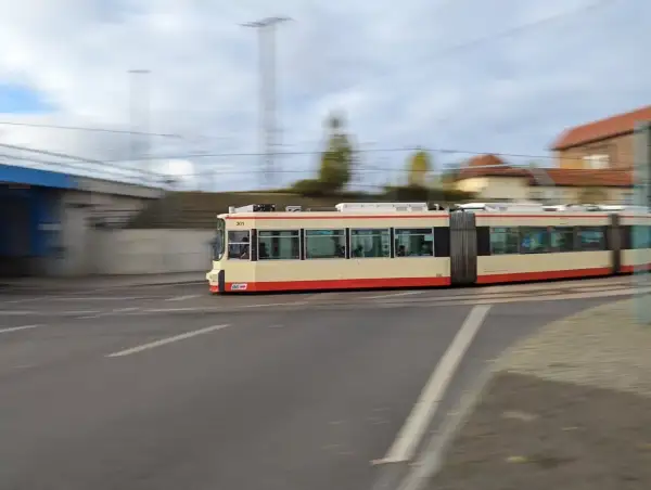 Ein langer, gelber und roter Straßenbahnzug fährt durch Wrocław. Mit jakdojade wrocław finde ich schnell die nächste Haltestelle.