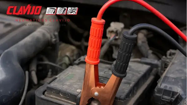 Pinzas rojas y negras conectando la batería de un coche. Ayuda a conectar bateria moto.