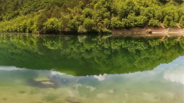 Verde smeraldo del lago di Boccafornace riflette la lussureggiante vegetazione che lo circonda, creando un'immagine speculare mozzafiato.