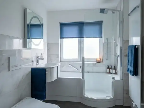 Modernes Bad mit Dusche und Wanne. Ein Beispiel, wann muss Vermieter Bad renovieren: bei starkem Verschleiß oder Mängeln.