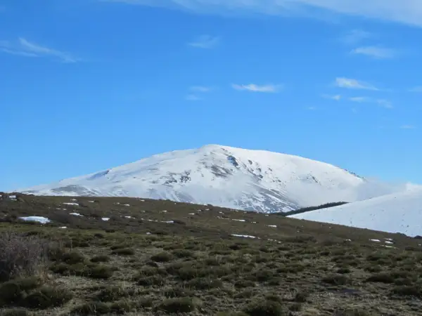 El pico más alto de Almería, cubierto de nieve, se alza majestuoso bajo un cielo azul despejado.