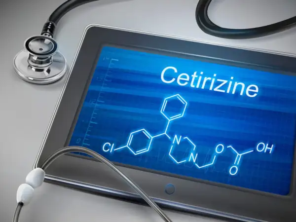 Tablet z ekranem wyświetlającym wzór chemiczny cetyryzyny i stetoskop.
