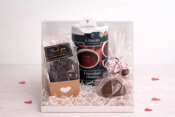 Confezione regalo con cioccolata calda in polvere, cioccolatini e un cuore di cioccolato. Un pensiero goloso, magari con un tocco di cioccolata al sale.