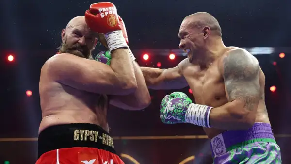 Two boxers clash in the highest weight class in boxing. Sweat flies as one lands a powerful punch, the other defends.