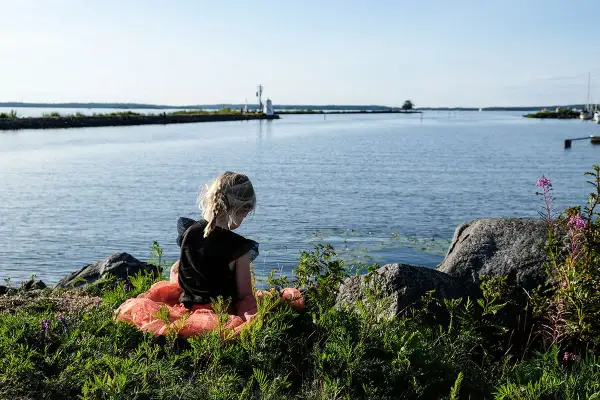 Flicka i tyllkjol vid vattnet nära ett vandrarhem i Mariestad.