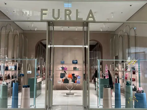 Elegancki butik Furla, gdzie furla co to za marka jest widoczna na szyldzie. W środku mnóstwo torebek i akcesoriów.