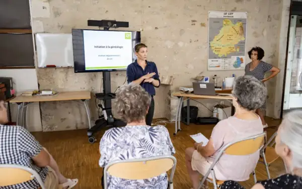 Une conférencière présente une initiation à la généalogie aux archives départementales du Lot.