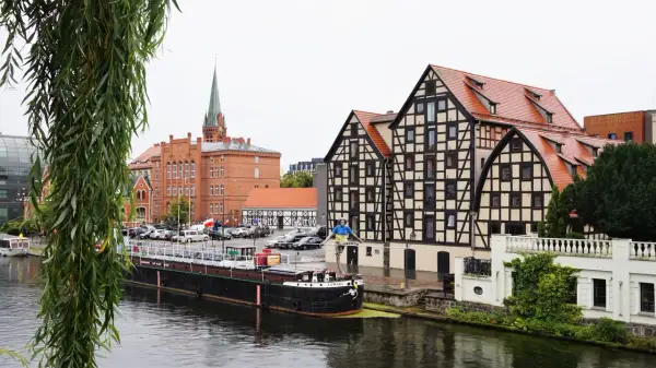 Bydgoszcz: nad Brdą, obok zabytkowych kamienic i ceglanego kościoła, cumuje barka. Nietypowe atrakcje Bydgoszcz czekają!