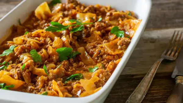 Herzhaftes Schichtkohl mit Hackfleisch, ein beliebtes DDR Rezept, serviert in einer weißen Auflaufform, garniert mit Petersilie.