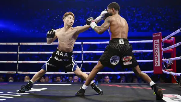 Two boxers clash in a packed arena. The frequency of how often boxers fight varies greatly depending on their level and schedule.