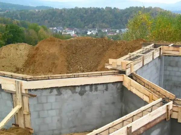 Fundamenty domu w budowie, zbrojenie i szalunki czekają na beton. Widać, ile jest ważne pozwolenie na budowę, by móc rozpocząć taką inwestycję.