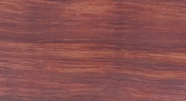 Textura rica y veteada de madera bubinga, con tonos rojizos y marrones que evocan la calidez de la naturaleza.